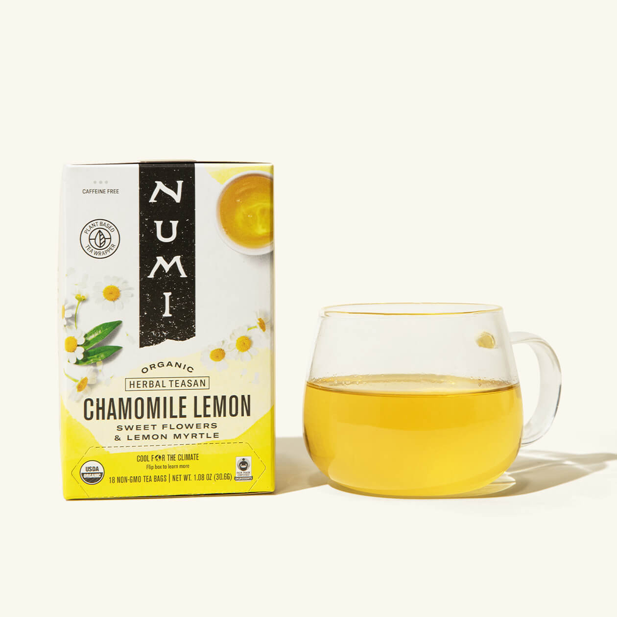 A box of Numi's Chamomile Lemon next to a brewed cup of tea in a clear cup