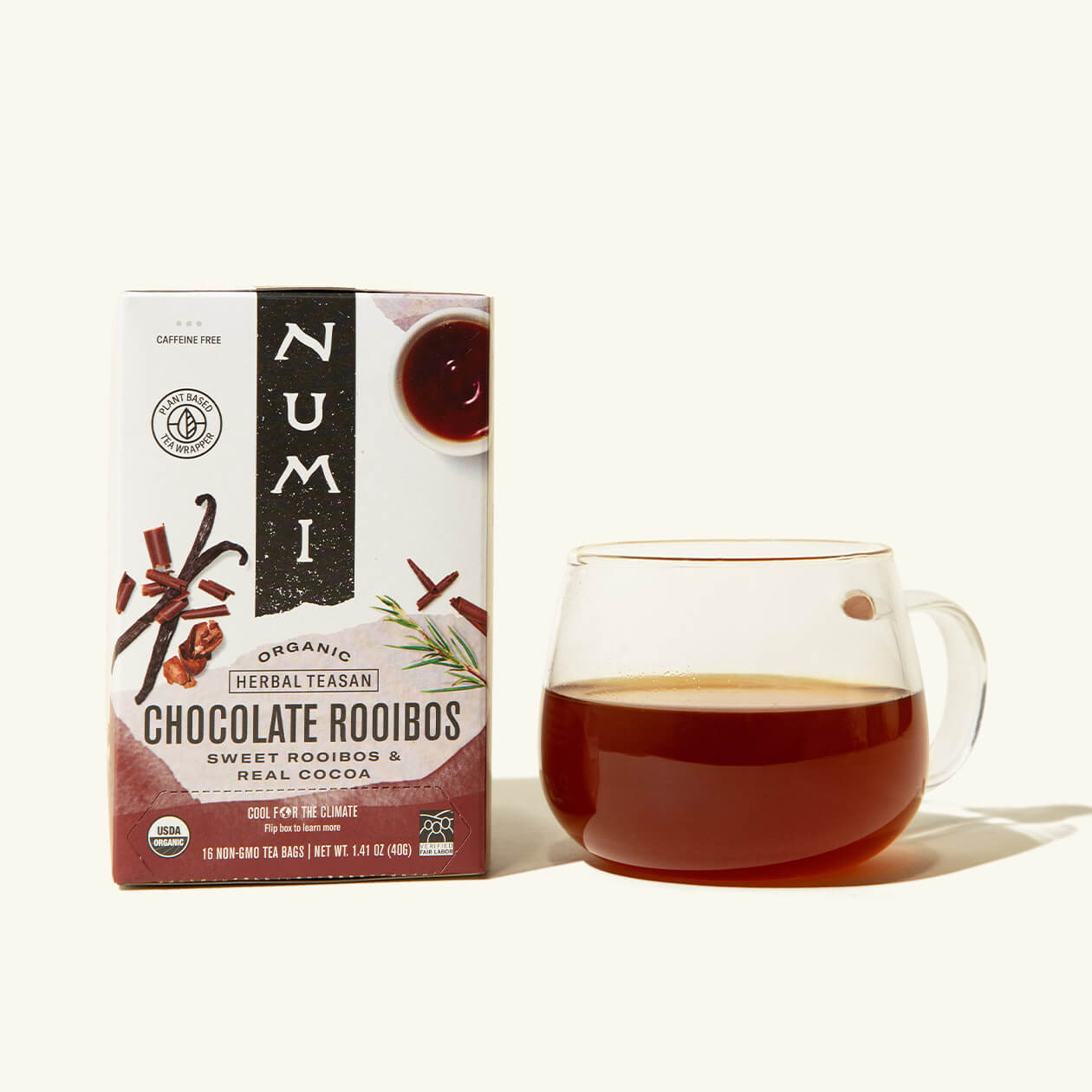 A box of Numi's Chocolate Rooibos next to a brewed cup of tea in a clear cup