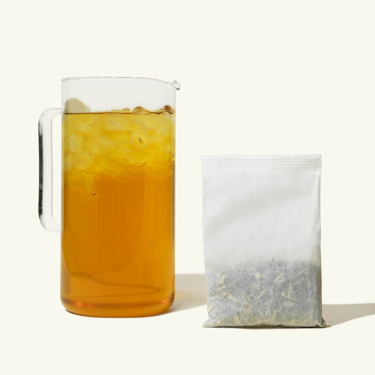 A pitcher of Numi Citrus Green Iced Tea with a gallon iced tea pouch