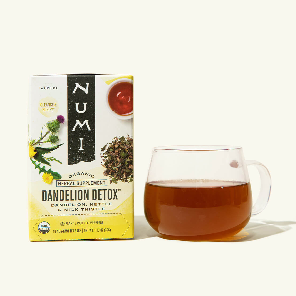 A box of Numi's Dandelion Detox next to a brewed cup of tea in a clear cup