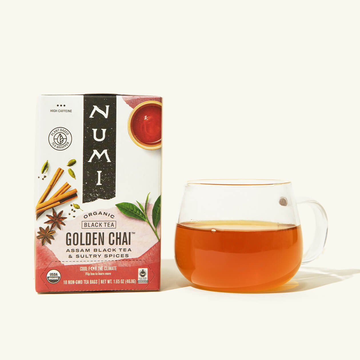 A box of Numi's Golden Chai next to a brewed cup of tea in a clear cup