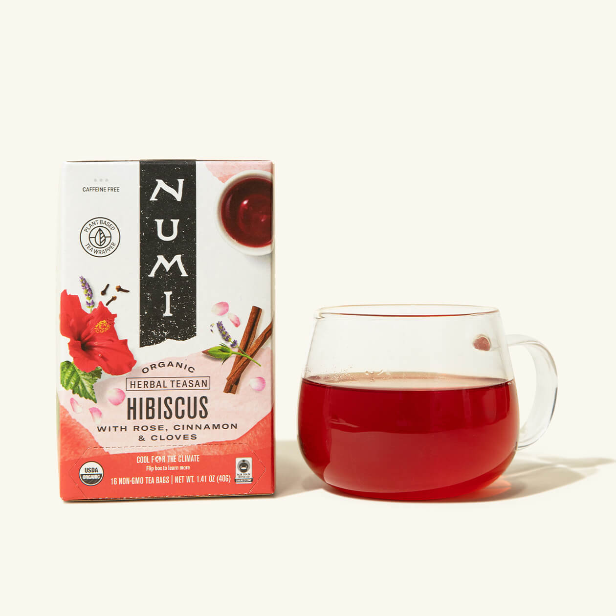 A box of Numi's Hibiscus next to a brewed cup of tea in a clear cup