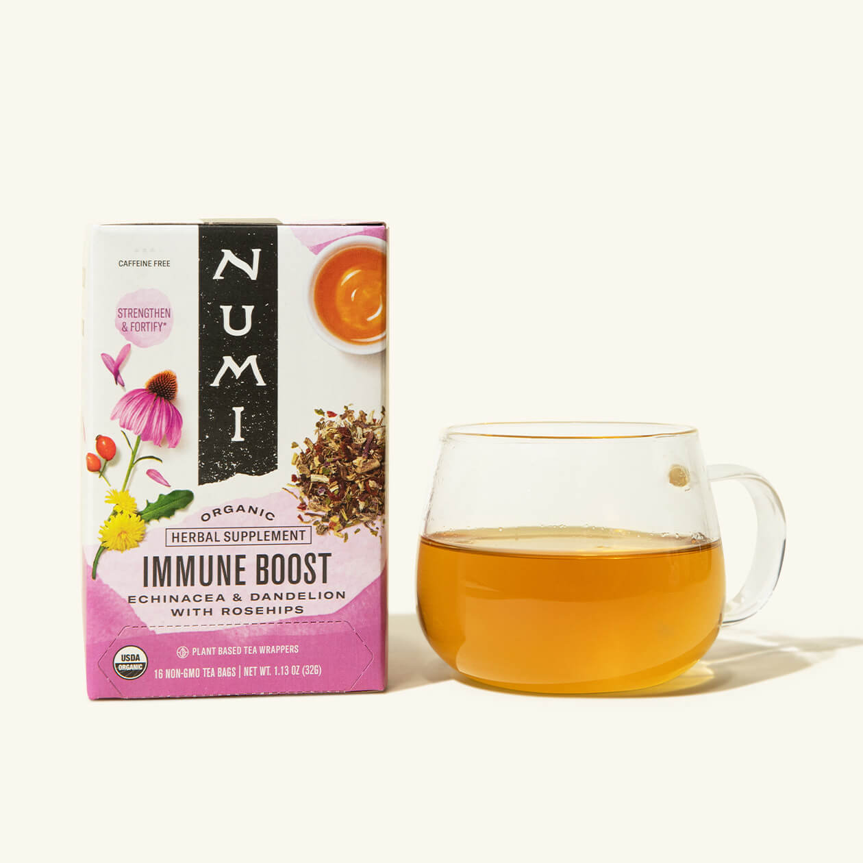 A box of Numi's Immune Boost tea next to a brewed cup of tea in a clear cup