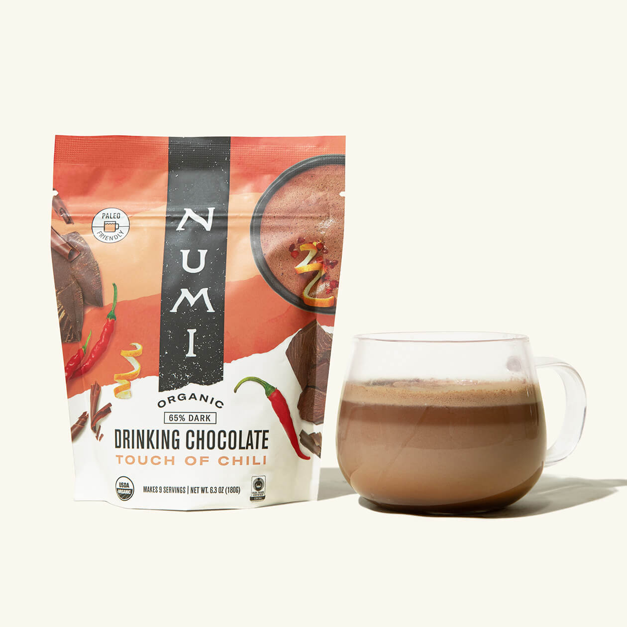 A pouch of Numi organic Drinking Chocolate, Touch of Chili Flavor, next to a cup of hot chocolate