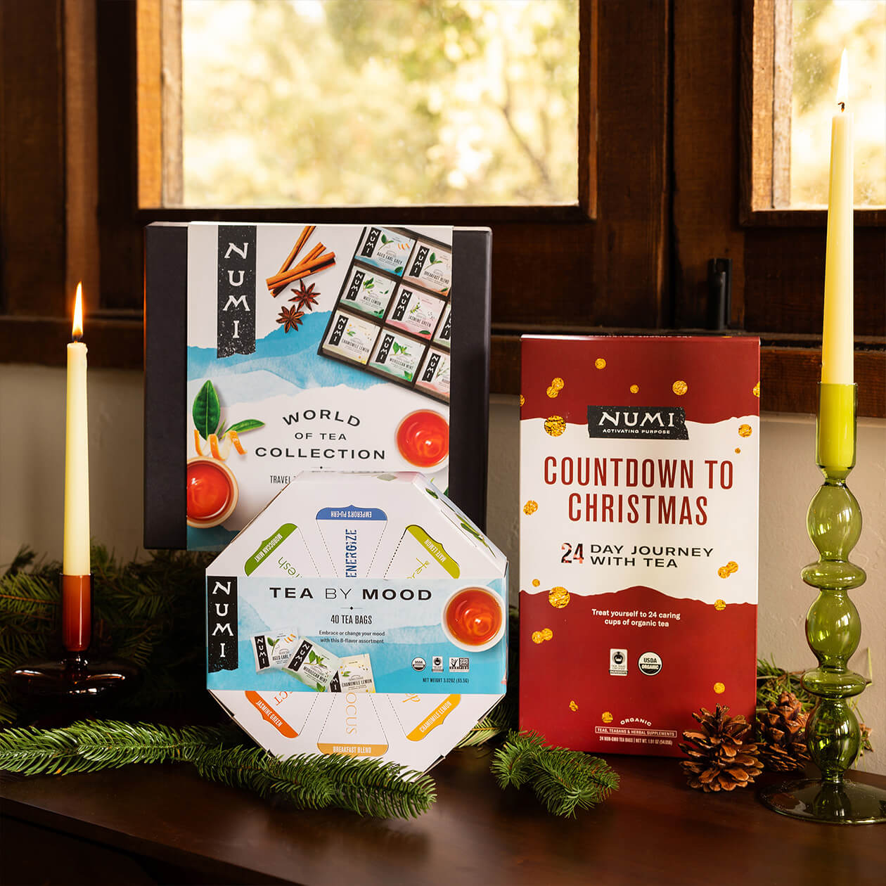 A collection of Numi Gifts, including Self-care Sampler, World of Tea and Advent Calendar in a holiday setting