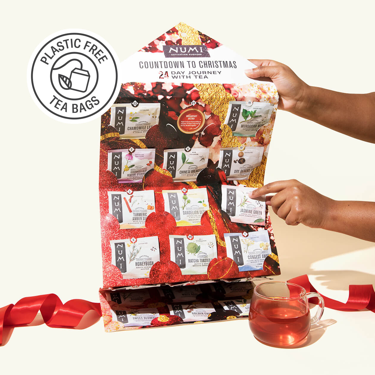 Numi tea gift set with plastic-free tea bags, a cup of tea, and a hand holding the packaging.