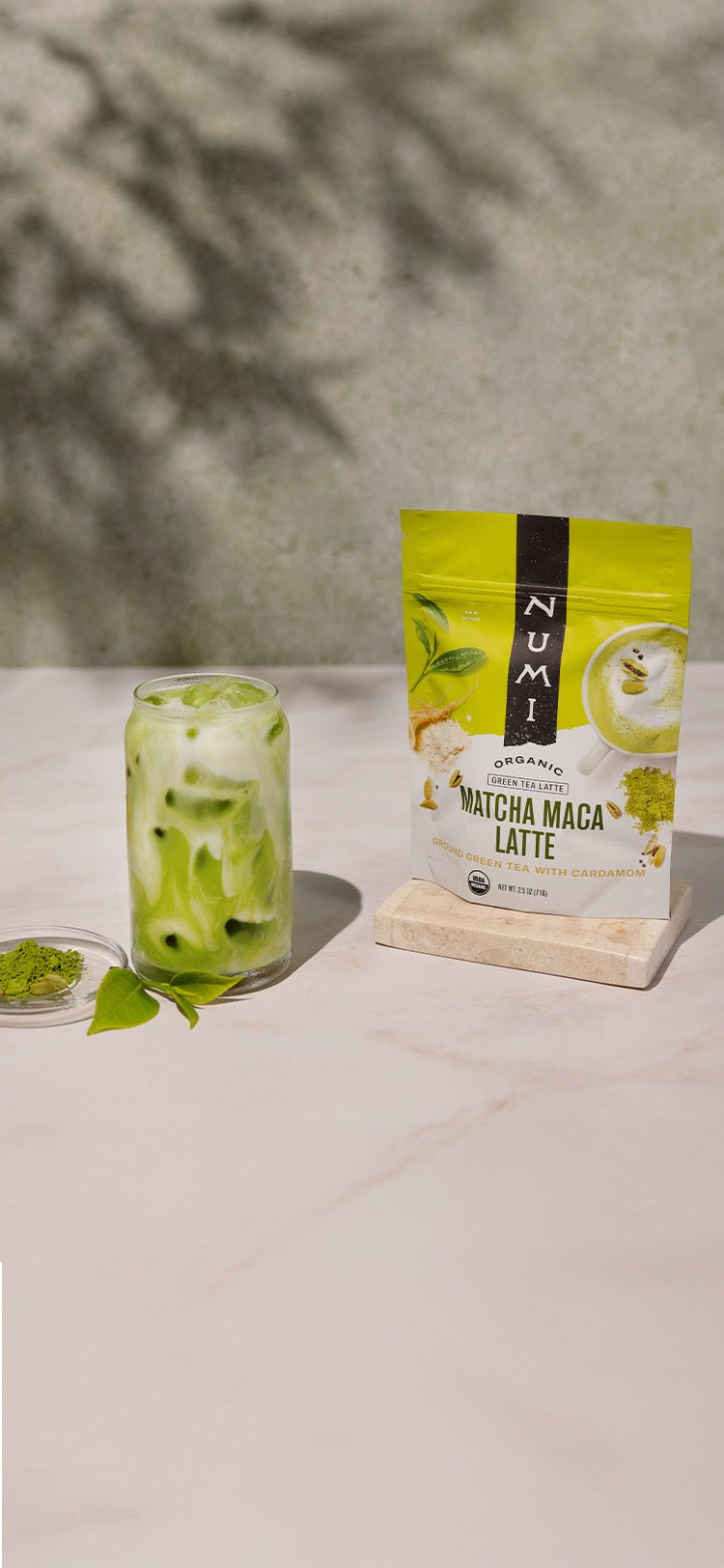 Numi Matcha Maca Latte package with a glass of matcha drink on a white surface.