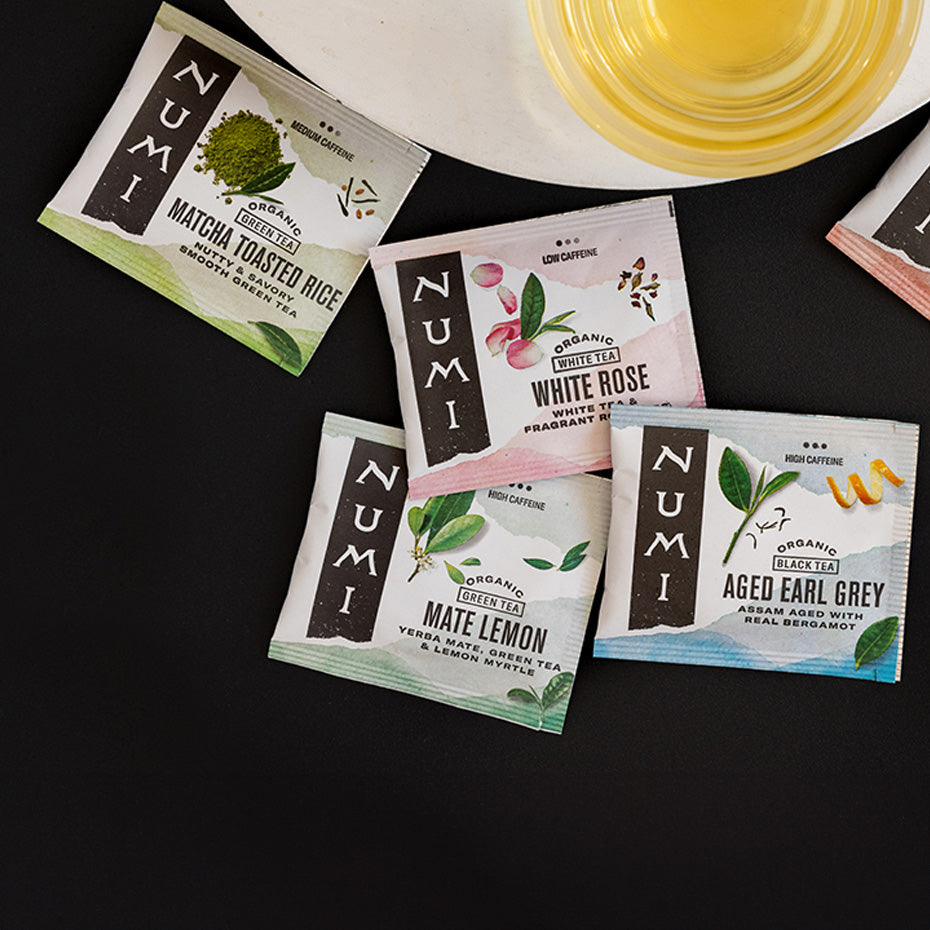 Numi plant-based tea wrappers next to a brewed cup of tea