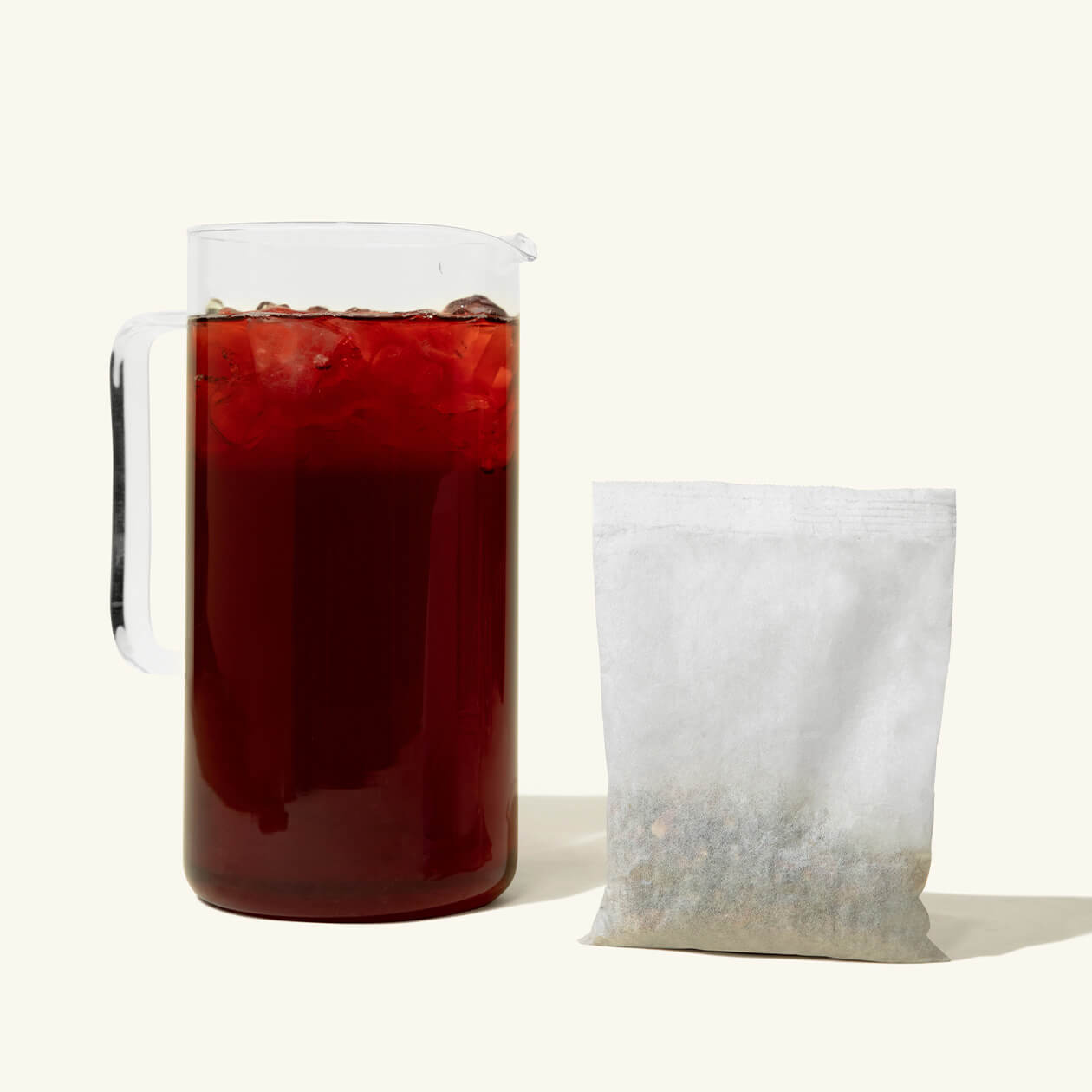 A pitcher of Numi Berried Treasures Iced Tea with a gallon iced tea pouch