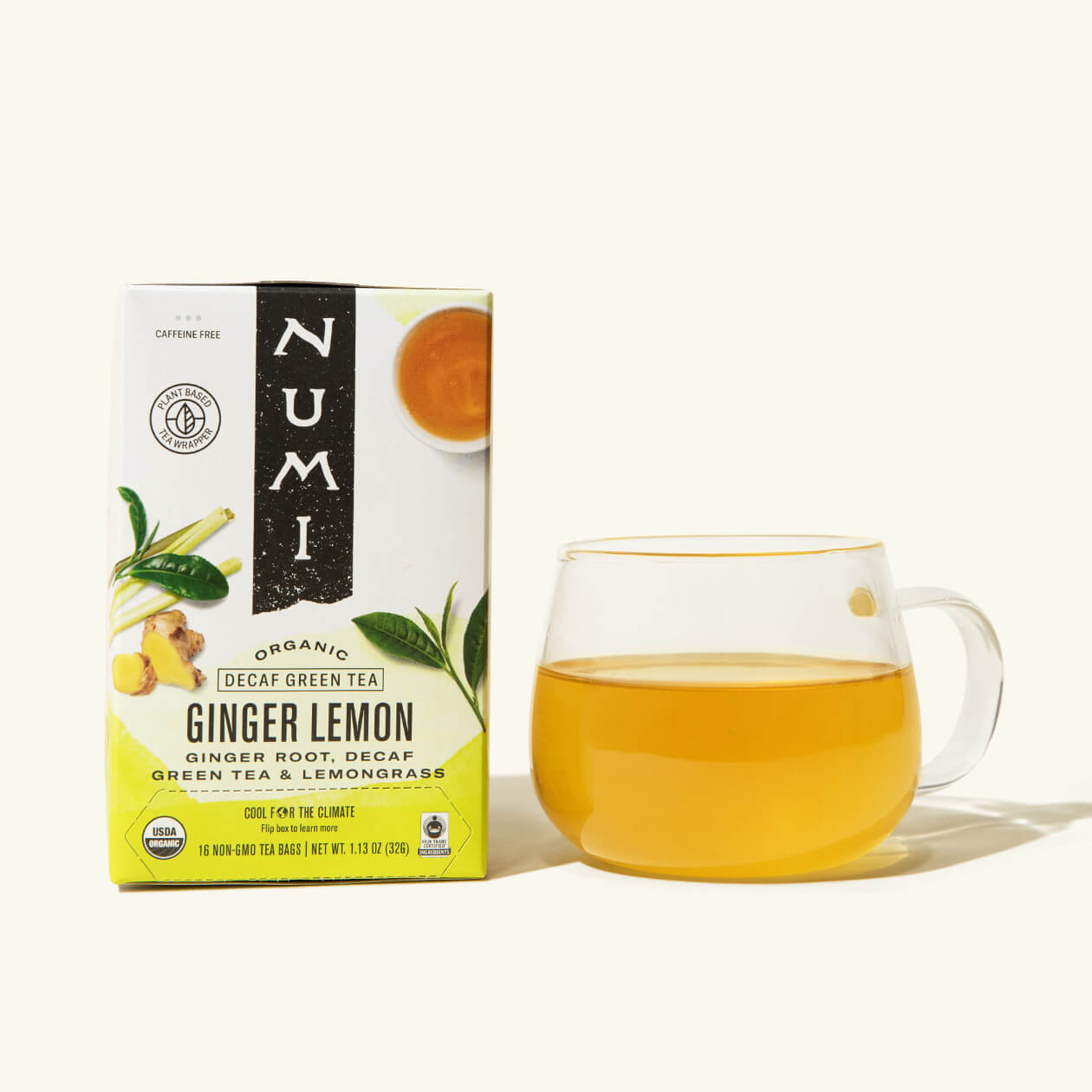 A box of Numi's Ginger Lemon next to a brewed cup of tea in a clear cup