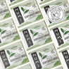 Pattern of Numi Gunpowder Green tea packages with a plastic-free logo.
