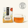 Numi Honeybush tea box with a glass of tea on a white background