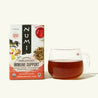 A box of Numi's Immune Support tea next to a brewed cup of tea in a clear cup