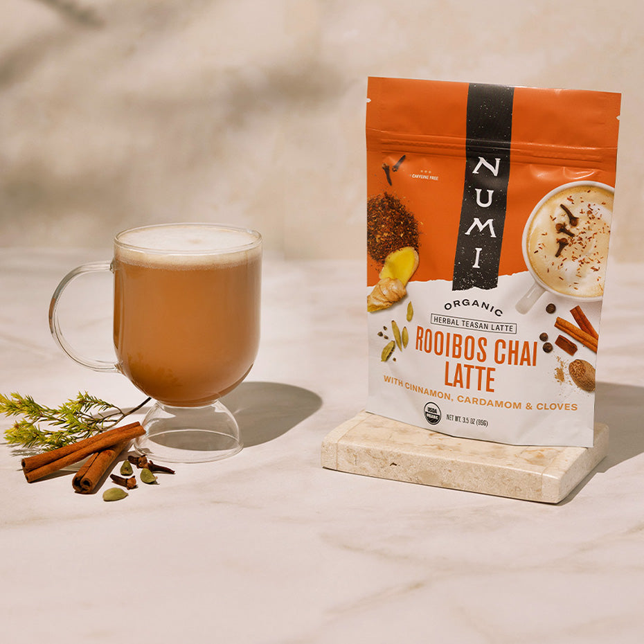 Numi Rooibos Chai Latte package with a glass of latte on a light surface.