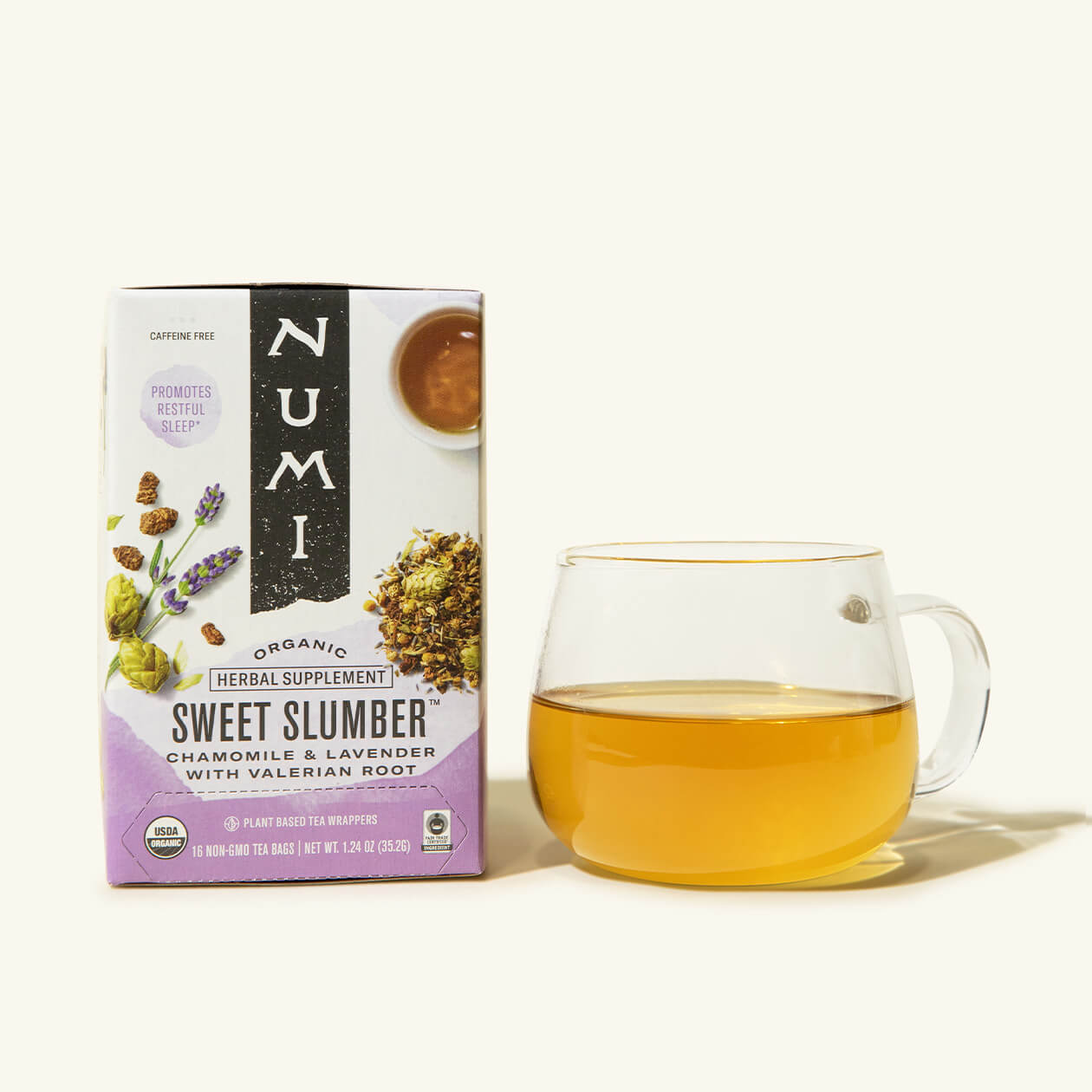 A box of Numi's Sweet Slumber tea next to a brewed cup of tea in a clear cup
