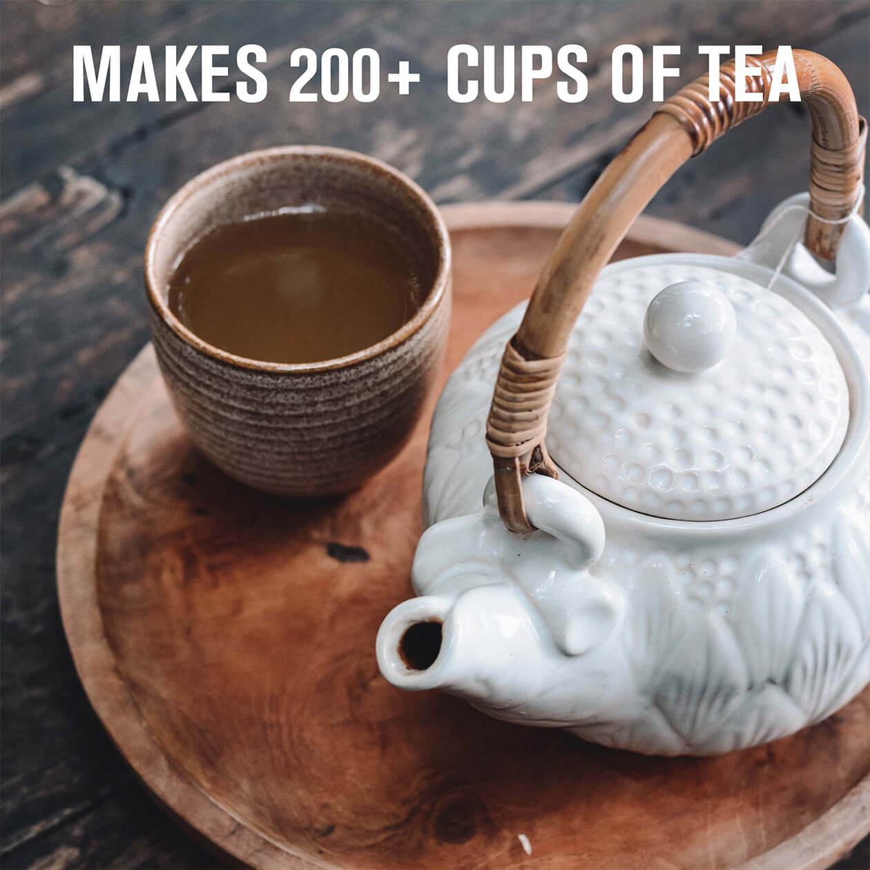 A tea pot and tea cup on a wood tray