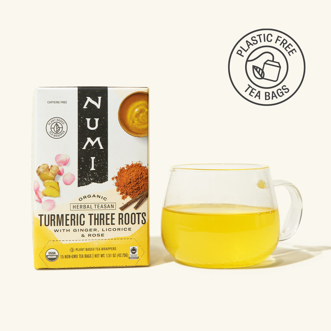 Numi Turmeric Three Roots tea box with a glass of tea on a white background